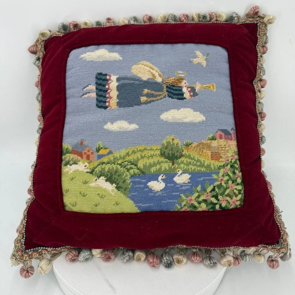 Needlepoint pillow featuring a folk art angel motif dark red velvet background